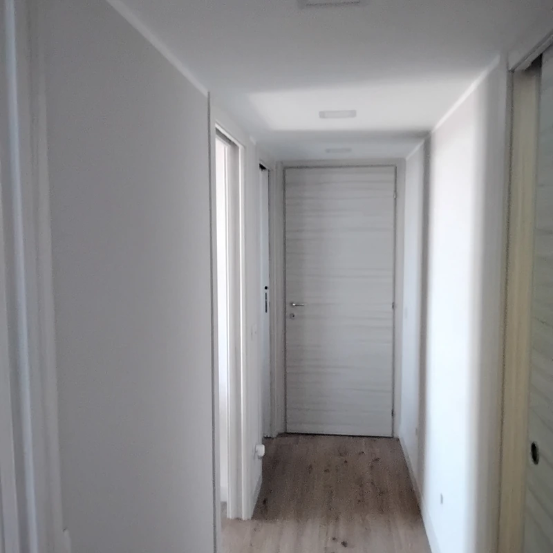 Corridoio con porte bianche e pavimento effetto legno